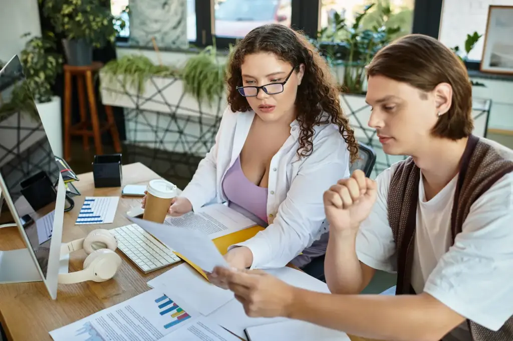 Two colleagues sitting at a desk reviewing business documents with an Orlando FL bookkeeper.