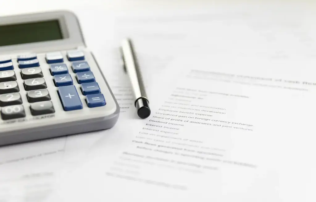 A calculator and a pen resting on a financial statement for bookkeeping services in Kissimmee.